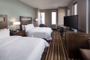 丹佛汉普顿套房酒店及丹佛市区会议中心的酒店客房设有两张床和一台平面电视。