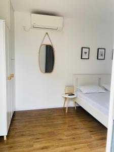 旧瓦马Daro tiny house的卧室配有一张床,墙上设有镜子