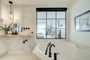 圣阿加瑟莫Les Lofts du Lac des Sables by KASANIA的白色的浴室设有浴缸和窗户。