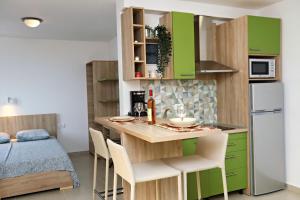 苏托莫雷奥克托普斯公寓的一间小厨房,配有绿色橱柜和桌椅
