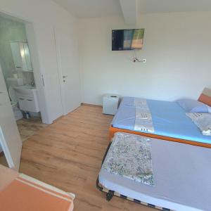 斯特鲁加Villa Bardha的小房间设有两张床和电视