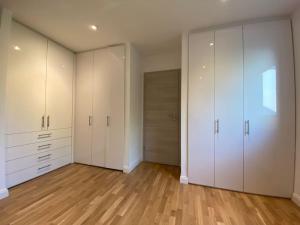 陶努斯山麓霍夫海姆Luxury apartment with air conditioning & Jaccuzzi near Frankfurt Wiesbaden的一间空房间,配有白色的橱柜和木地板
