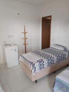 巴雷里尼亚斯POUSADA ROSA DOS LENÇÓIS的一间卧室配有一张床和一台冰箱