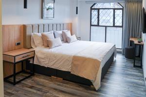 波哥大86 suites的一间卧室配有一张大床、一张桌子和一个窗户。