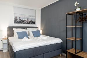 杜伊斯堡Federnest - Luxus-Studio - Kingsize Boxspringbett - Home-Office mit Monitor und Drucker - 11 Min Hbf的一间卧室配有一张带蓝色墙壁的大床