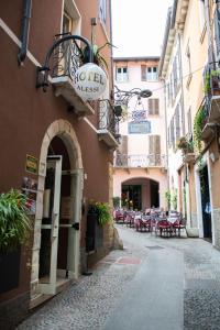 代森扎诺-德尔加达Alessi Hotel Trattoria的大楼内带桌椅的小巷
