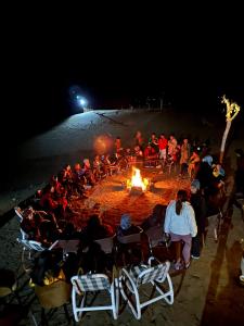 锡卡都Oasis Resort的一群人坐在海滩上的火堆旁