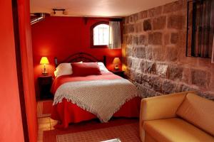 Mulaló哈托维德庄园酒店的红色卧室配有床和椅子