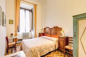 佛罗伦萨阿尔伯格圣乔瓦尼酒店的一间卧室设有一张大床和一个窗户。