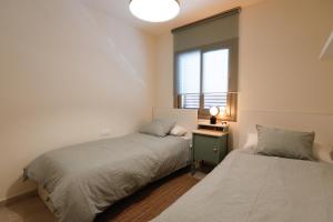 马塔罗Mediterranean City的带窗户的客房内的两张床