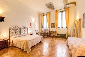 佛罗伦萨阿尔伯格圣乔瓦尼酒店的一间卧室配有两张床和一张桌子及椅子
