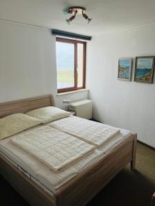 海利根港Seaview, Beach, Sunsets, Nature的一间卧室设有一张大床和窗户