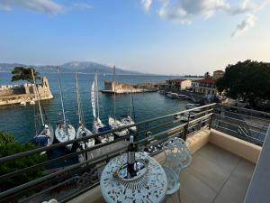 纳弗帕克托斯Vip Lepanto Port Suites的阳台配有桌椅和船只。