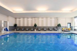 弗赖拉辛Residence Inn by Marriott Dallas Frisco的酒店客房的大型游泳池配有椅子