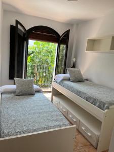 贝莱斯德韦瑙达利亚La Bicicleta, Duplex en Vélez Benaudalla的一间卧室设有两张床和大窗户