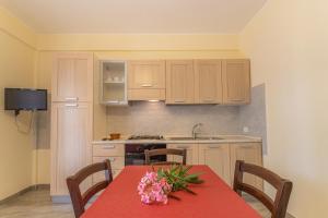 兰佩杜萨Case Vacanze Maluk的厨房配有一张桌子,上面有红色的桌布