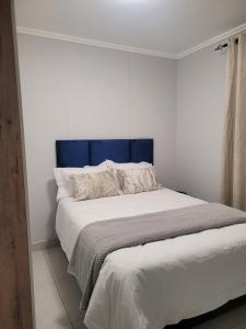 德班Two Bedroom Apartment的卧室里一张带蓝色床头板的床