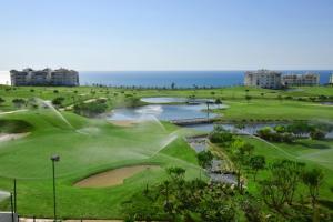 艾西拉Asilah Marina Golf的享有高尔夫球场和大海的空中景致