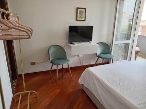 萨萨里莱特莱斯塔西维特住宿加早餐旅馆的卧室里设有两张绿色椅子,配有电视