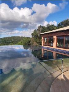 马塞约Bangalô Villas do Pratagy 1 Dormitório e Varanda的水景房屋 - 带游泳池