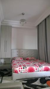 突尼斯哥扎娜公寓的一间卧室配有一张带红白毯子的床