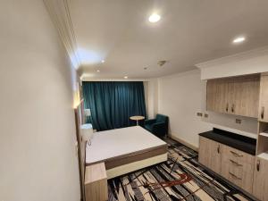 迪拜Helnan Royal的小房间,配有床和蓝色窗帘