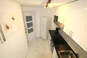贝尼多姆Panorama Benidorm Torre Montecarlo的白色的厨房配有水槽和冰箱