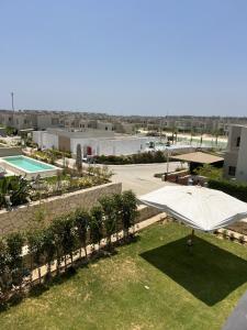 艾因苏赫纳Azha Luxury vacation villa Ain sokhna - families only的一个带白色遮阳伞和游泳池的庭院