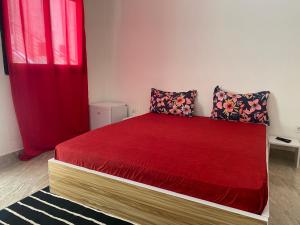 达喀尔RESIDENCE EL HADJI的一间卧室配有一张红色床罩的床