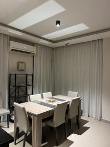 艾因苏赫纳Azha Luxury vacation villa Ain sokhna - families only的一间带桌子和白色椅子的用餐室