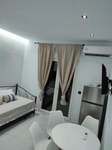 梅塔诺佛希斯Alexander Luxury Apartments & Studios的卧室配有一张床和一张桌子及椅子