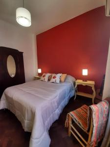 里奥夸尔托CasaOma的一间卧室设有两张床和红色的墙壁