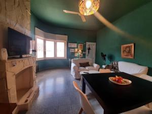 里奥夸尔托CasaOma的客厅设有绿色的墙壁和一张带果盘的桌子