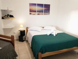 伊利亚孔普里达Recanto da Lagoa Flat的一间卧室配有一张带绿毯的床