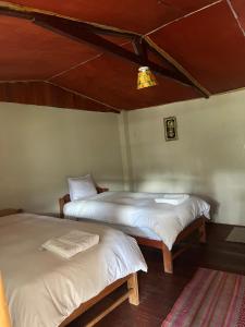 SahuayacuRefugio de Mery Lucmabamba的配有白色床单的客房内的两张床