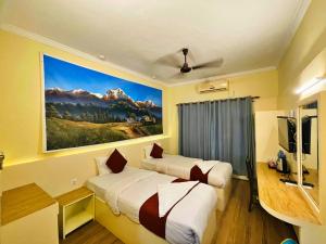 拉明德Hotel Peaceland Lumbini的酒店客房设有两张床,墙上挂有绘画作品