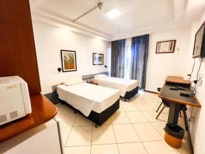 巴西利亚Apart Hotel em Brasília - MA Empreendimentos的酒店客房配有两张床和一张书桌