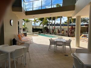 卡伦德拉Exclusive Apartment with Ocean Views的一个带桌椅的庭院和一个游泳池