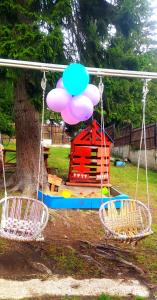 博尔若米Tsemi My House的公园里秋千,有房子和热气球
