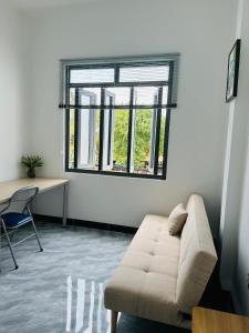 伊缇天福Koi Guest House - Phan Thiết的带沙发、书桌和窗户的客厅