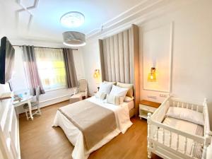 胡塞马Appartement LOUIS XIV avec HAMMAM SAUNA JACCUZI PRIVATISÉ TOTALEMENT GRATUIT SANS SUPPLÉMENT !的白色卧室配有床和书桌