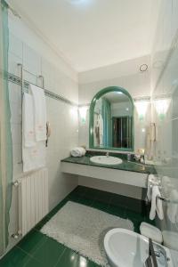 托尔托纳茱莉亚别墅酒店的白色的浴室设有水槽和镜子