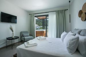 法里拉基Nόka Suite Apartments的一间卧室配有一张床,上面有两条毛巾