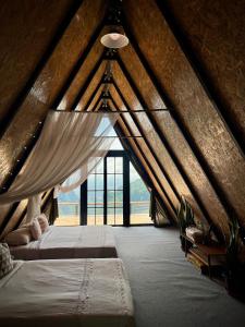 美塞บ้านหิ่งห้อยผาหมี Baanhinghoi phamee的阁楼卧室设有两张床和窗户。