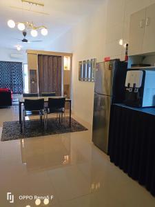 古晋ASFA Homestay Kuching的厨房配有冰箱和桌椅