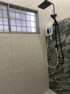 山打根Lisa Homestay Sandakan的浴室设有淋浴,墙上配有吹风机