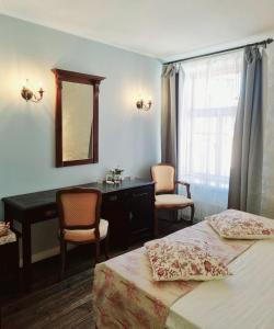 塔林Taanilinna Hotell的一间卧室配有两张床、一张桌子和一面镜子