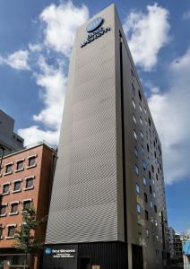 东京东京秋叶原菲诺贝斯特韦斯特酒店的一座高大的建筑,旁边是钟