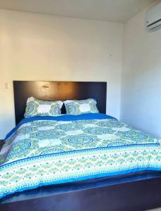 塔马林多Casa Mar de Sueños Tamarindo的一张带蓝色棉被和两个枕头的床