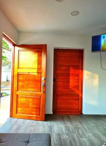 塔马林多Casa Mar de Sueños Tamarindo的一间设有木门和电视的客房